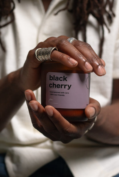 Person holding a container labeled 'black cherry' with a blurred background
